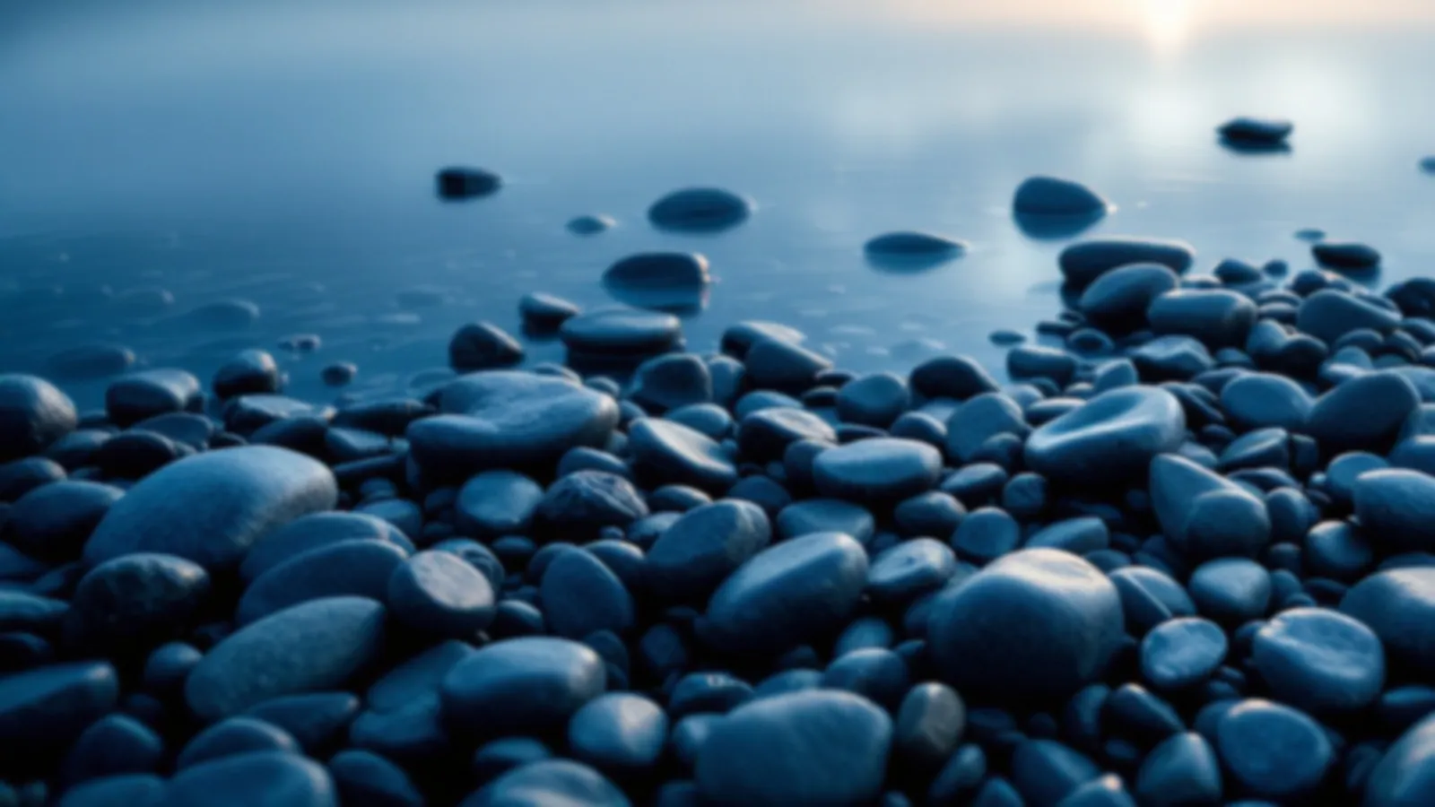 Smooth round pebbles at the edge of a calm clear lake at dawn, the AutoPebble view of car repair loans online, $100 – $5,000